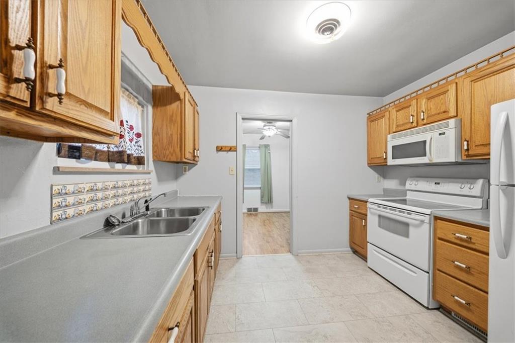 828 Dearborn Street Baden, PA 15005 - Photo 16 of 26 a kitchen with stainless steel appliances granite countertop a sink and dishwasher a stove top oven with wooden floor