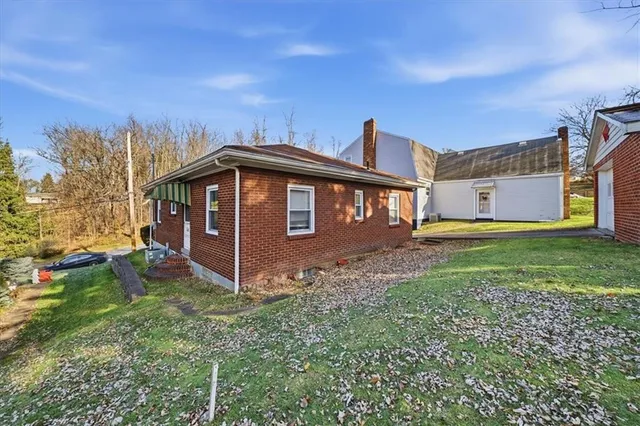 a view of a house with yard and sitting area