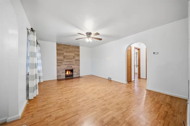 a view of an empty room with a fireplace and a window