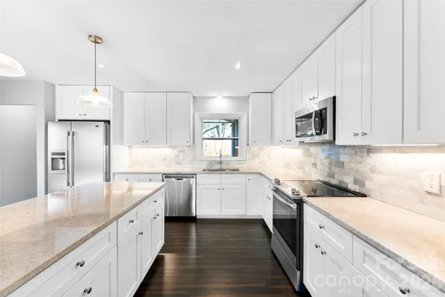 a kitchen with granite countertop cabinets stainless steel appliances a sink and a center island