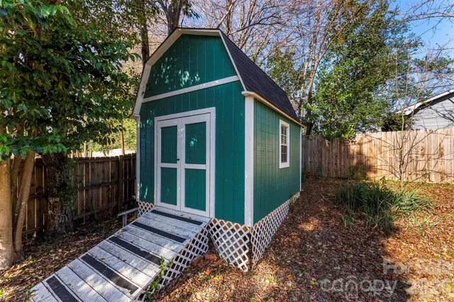 a view of a house with a small yard plants and wooden fence
