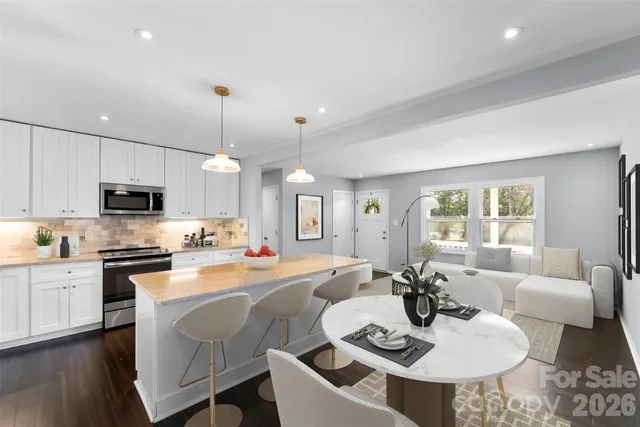 a large kitchen with granite countertop a stove a sink a dining table and chairs