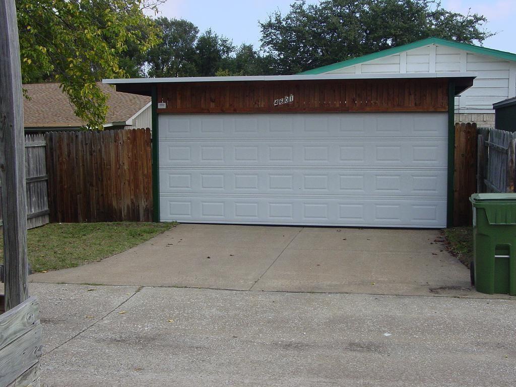 4601 Elm Ridge Lane Garland, TX 75044 - Photo 16 of 21 Attached single-car garage with a paneled door, concrete driveway, and wood-paneled trim