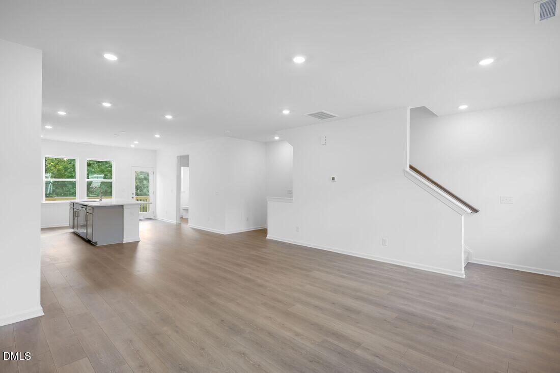 430 Rowe Way Knightdale, NC 27545 - Photo 7 of 51 a view of an empty room with wooden floor and windows