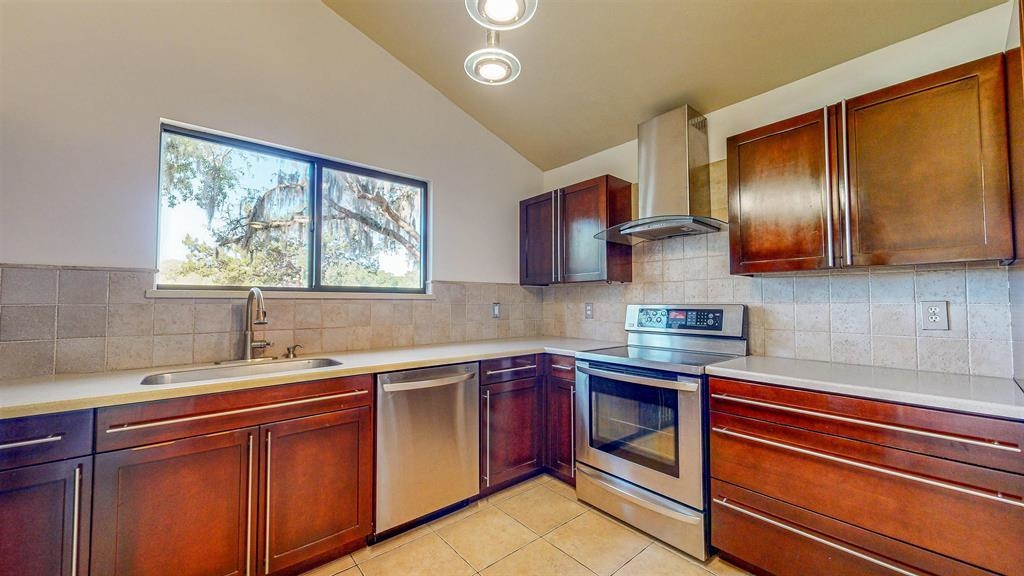 100 Saturn Road St. Augustine, FL 32086 - Photo 4 of 29 a kitchen with stainless steel appliances granite countertop a sink stove and microwave