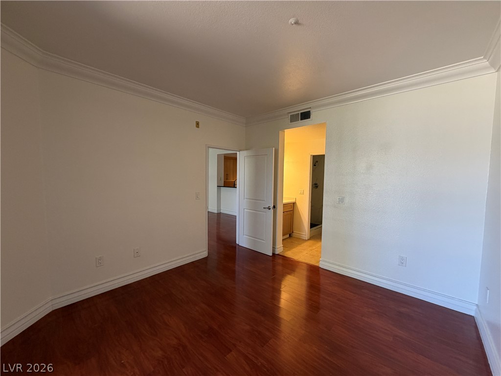 210 East Flamingo Road, Unit 126 Las Vegas, NV 89169 - Photo 8 of 16 Rich hardwood flooring stretches across this airy living space with elegant crown molding accents.