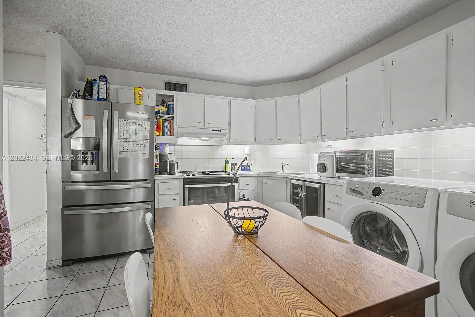 13045 Southwest 68th Street, Unit 111 Miami, FL 33183 - Photo 5 of 15 a kitchen with a refrigerator sink and cabinets