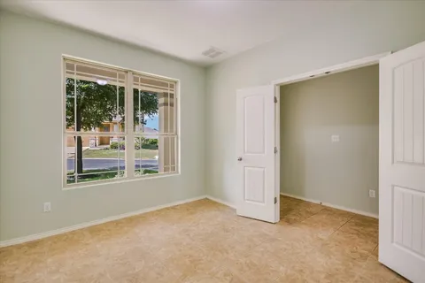 an empty room with windows and closet