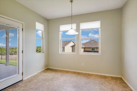 a view of an empty room with window and cabinet