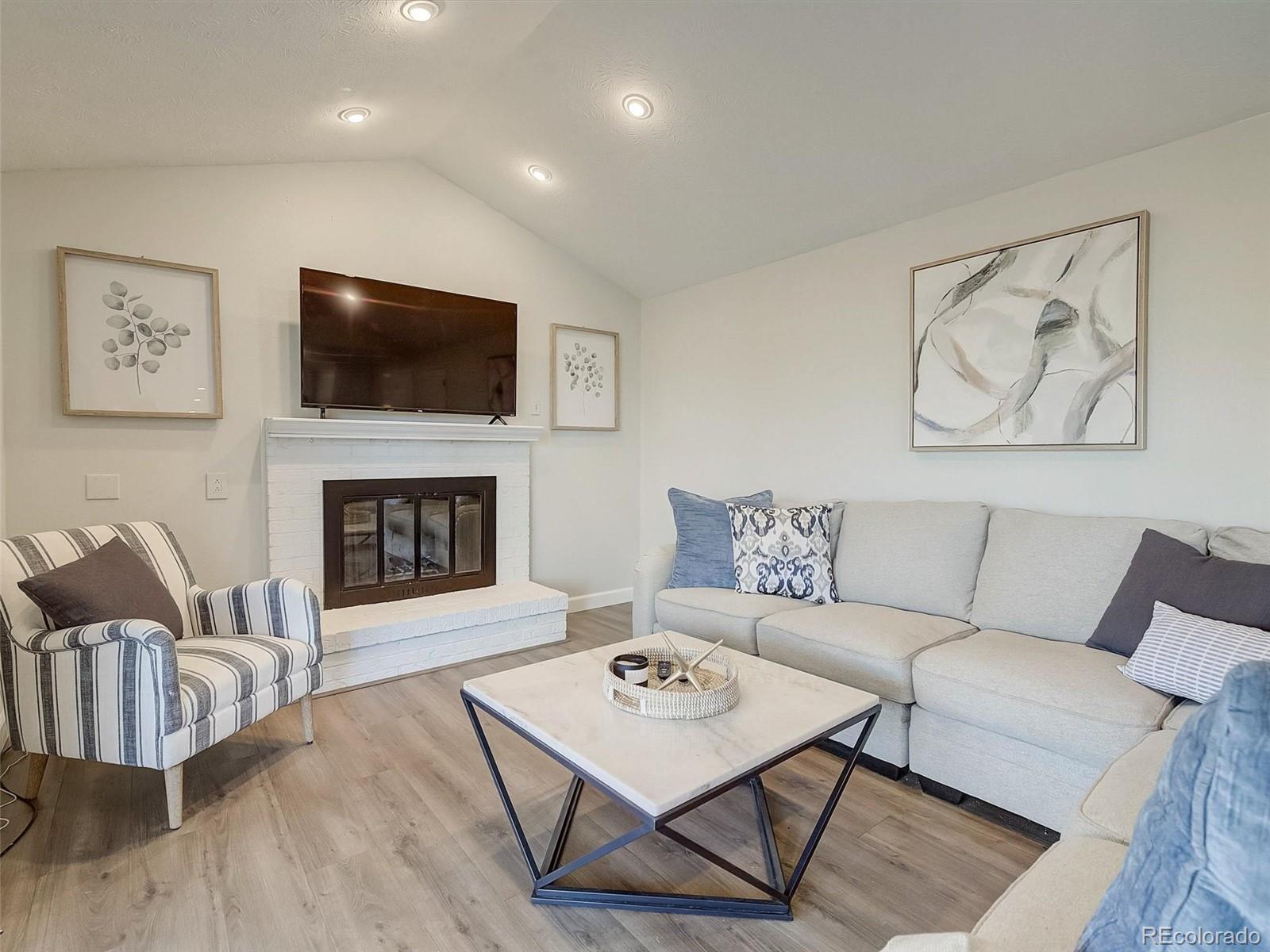 6432 South Birch Circle Centennial, CO 80121 - Photo 12 of 40 a living room with furniture a flat screen tv and a fireplace