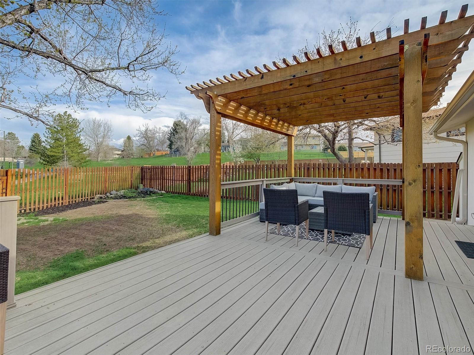 6432 South Birch Circle Centennial, CO 80121 - Photo 33 of 40 a view of a deck with table and chairs a barbeque with wooden floor and roof