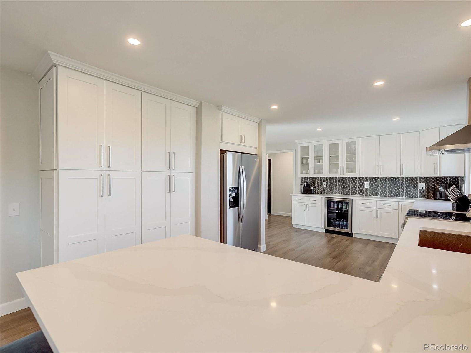 6432 South Birch Circle Centennial, CO 80121 - Photo 6 of 40 a large white kitchen with kitchen island a refrigerator a sink dishwasher with a stove and oven