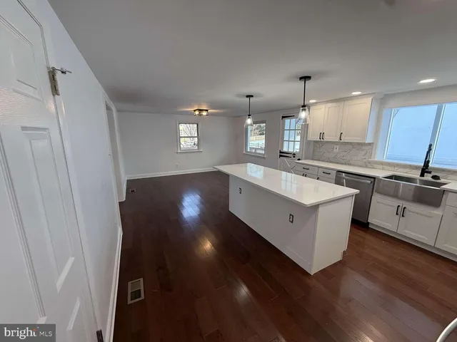 a kitchen with stainless steel appliances granite countertop a sink a stove a refrigerator and cabinets