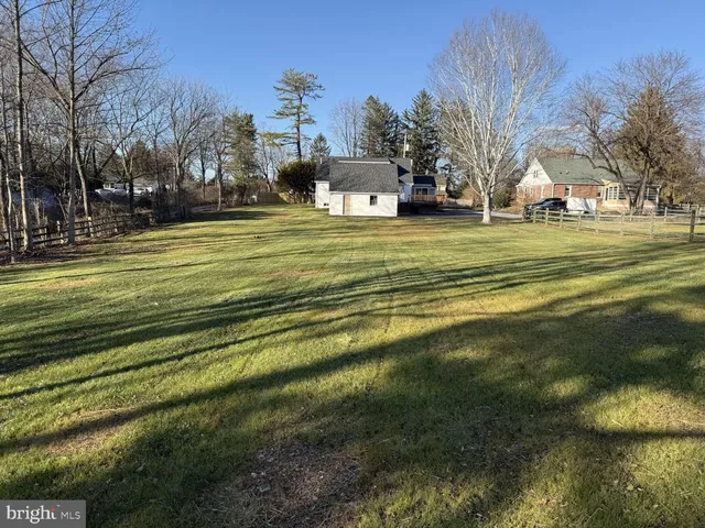 a view of a house with a big yard and large trees