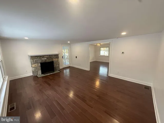 an empty room with wooden floor and fireplace