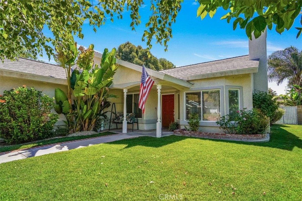 a view of a house with a yard and potted plants
