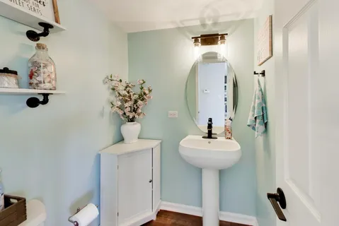 a bathroom with a sink a mirror and a potted plant
