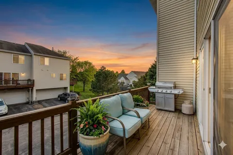 a view of a balcony with chairs and wooden floor