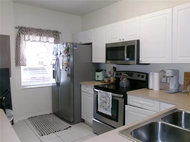 a kitchen with granite countertop a refrigerator and a stove top oven