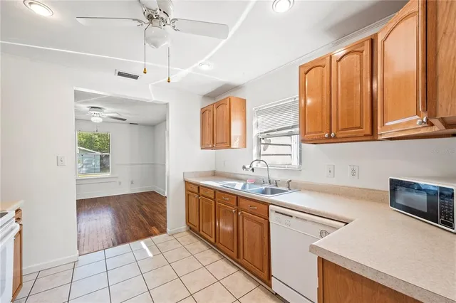 a kitchen with a sink a stove cabinets and a window