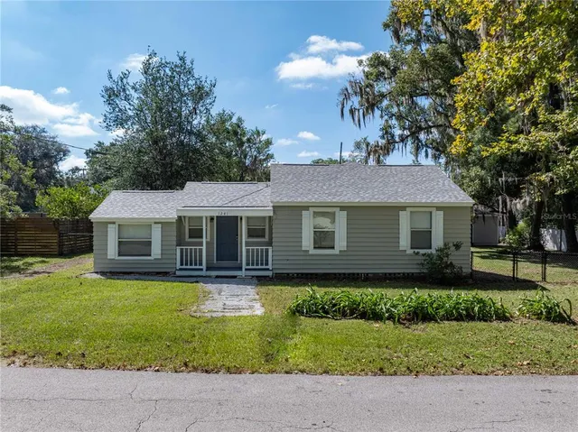 a front view of a house with a yard garage and outdoor seating
