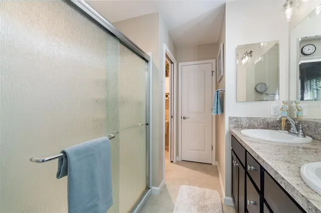 a bathroom with a granite countertop sink a mirror and a shower
