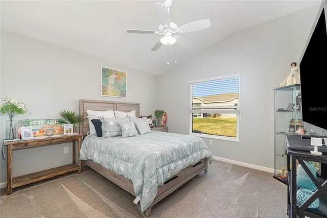 a bedroom with a bed chandelier and a window