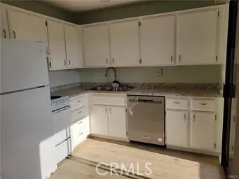 a kitchen with granite countertop white cabinets and white appliances