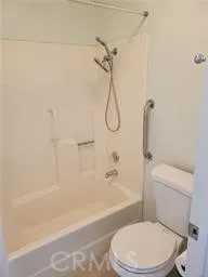 a white toilet and tub sitting next to a bathroom sink