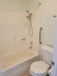 a white toilet and tub sitting next to a bathroom sink