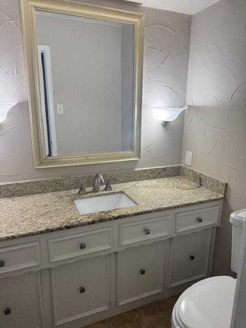 14922 Hillcrest Road Dallas, TX 75248 - Photo 11 of 19 a bathroom with a granite countertop toilet sink and mirror