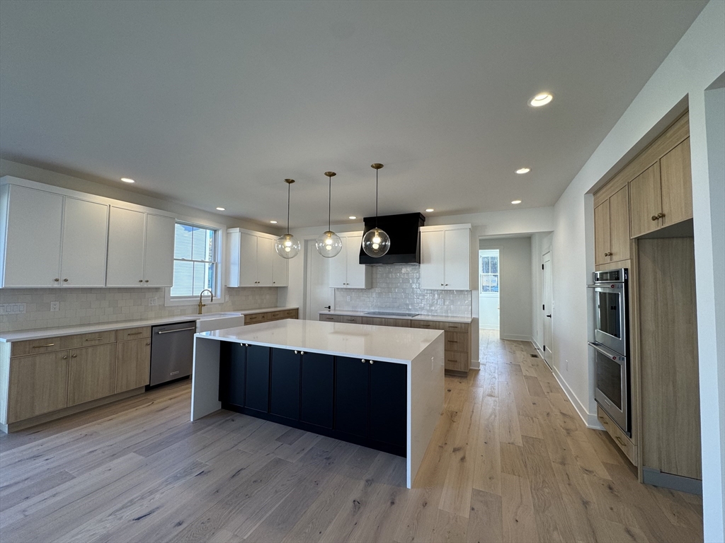 12 Old County Road, Unit 20 Hudson, MA 01749 - Photo 21 of 30 a large kitchen with stainless steel appliances kitchen island a large counter top and wooden floors