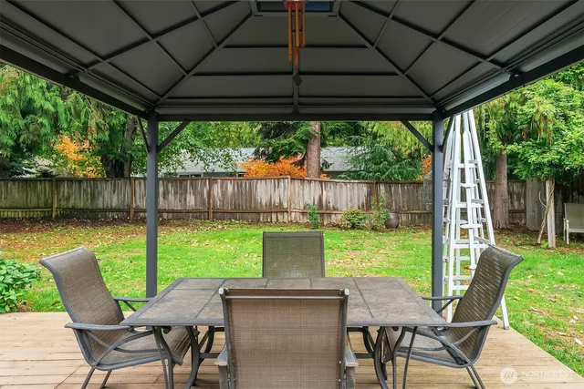 a view of a patio with a table chairs and a backyard
