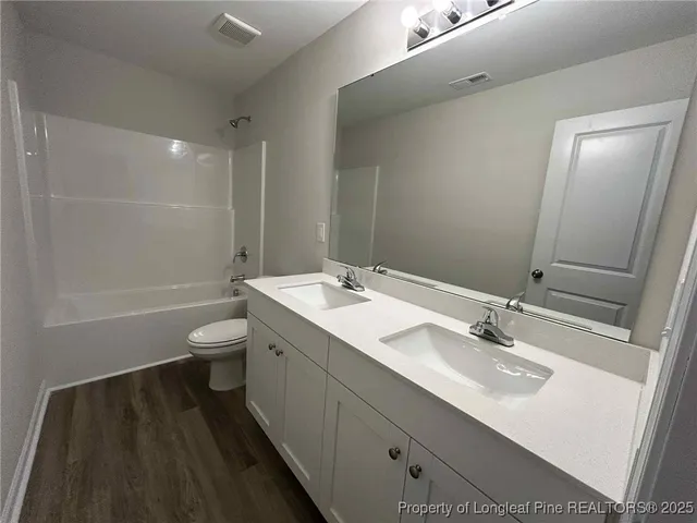 a bathroom with a sink toilet a mirror and shower