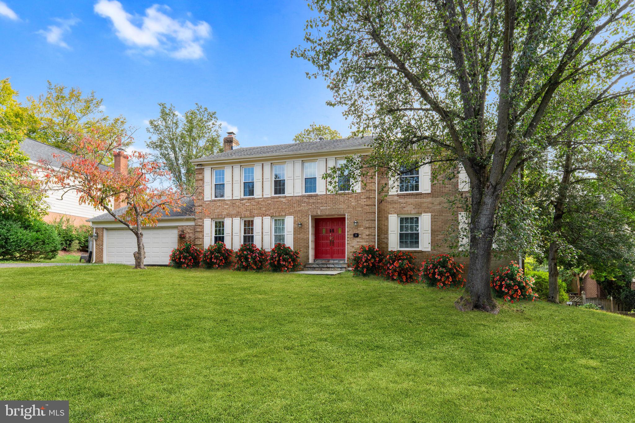a view of a house with a big yard and large trees