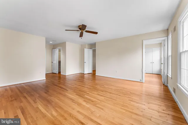 an empty room with wooden floor and windows