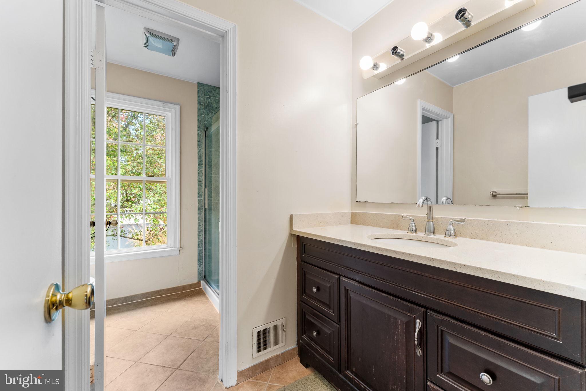 9 Snug Hill Court Potomac, MD 20854 - Photo 25 of 66 a bathroom with a sink a vanity and a mirror