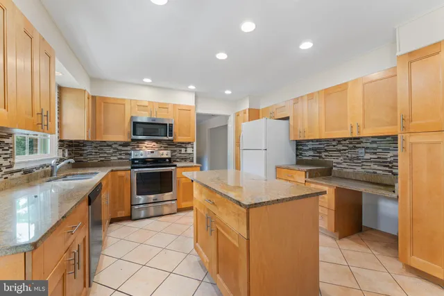 a kitchen with a sink a stove top oven and refrigerator