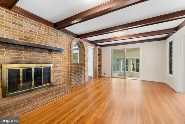 a view of empty room with wooden floor and fireplace