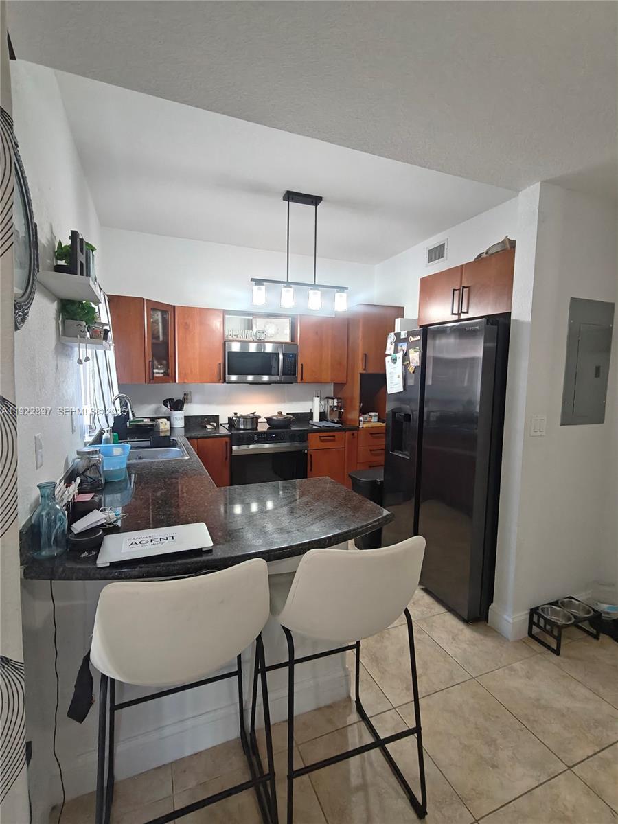 17847 Northwest 74th Path Hialeah, FL 33015 - Photo 15 of 35 a kitchen with stainless steel appliances a refrigerator a stove a sink cabinets and a dining table