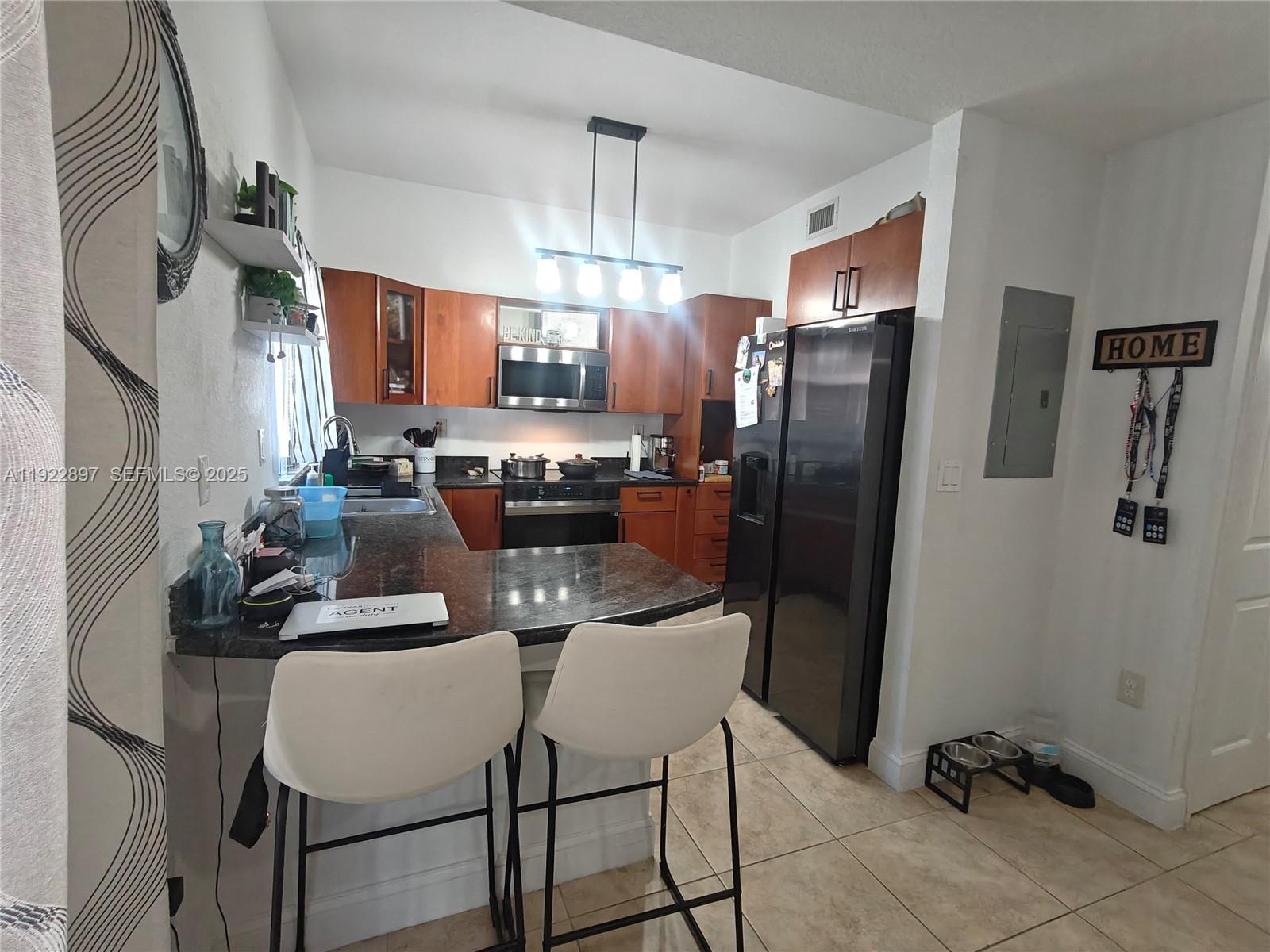 17847 Northwest 74th Path Hialeah, FL 33015 - Photo 16 of 35 a kitchen with refrigerator and chairs
