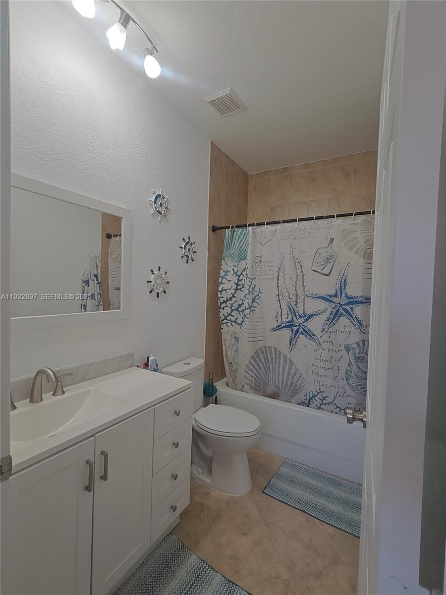 17847 Northwest 74th Path Hialeah, FL 33015 - Photo 28 of 35 a bathroom with a granite countertop sink a toilet and a shower