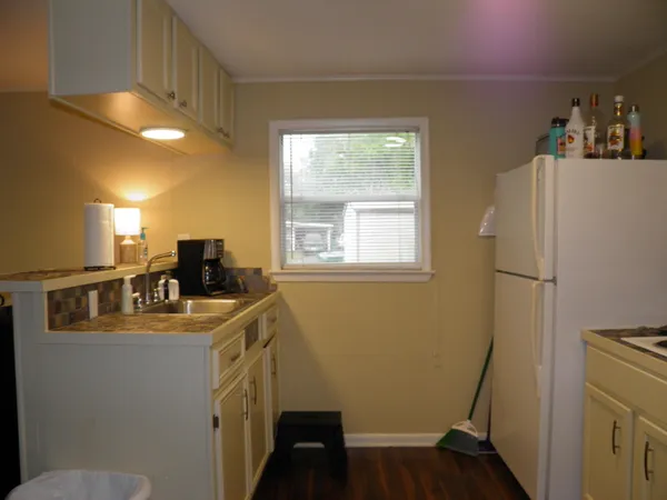 a kitchen with a refrigerator a sink and wooden floor