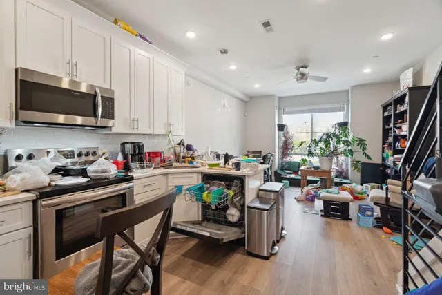 a kitchen that has a lot of cabinets a sink and appliances in it