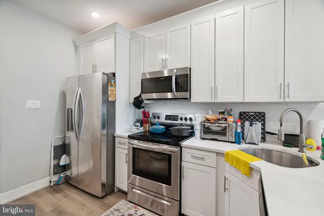 a kitchen with stainless steel appliances granite countertop a refrigerator sink and stove