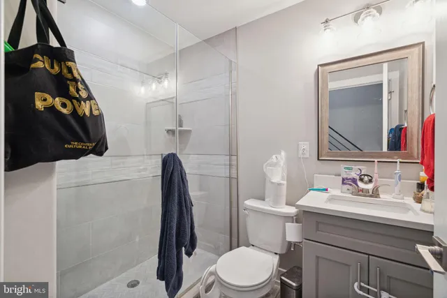 a bathroom with a sink vanity mirror and toilet