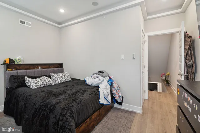 a bedroom with a bed and a flat tv screen on a dresser