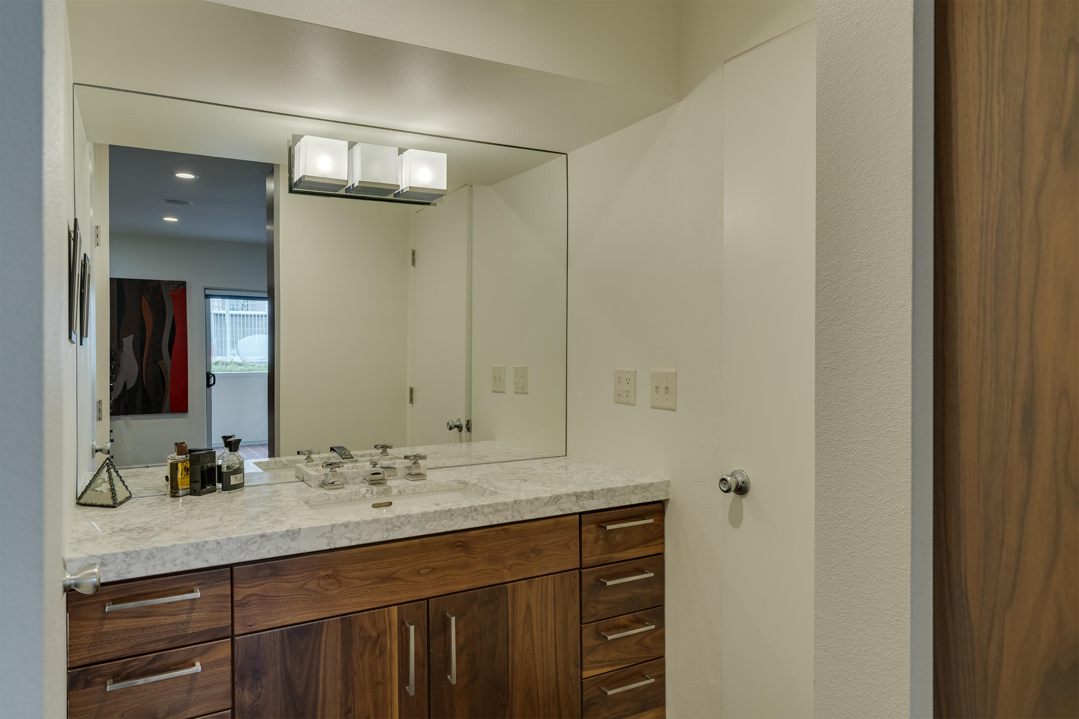 277 East Alejo Road, Unit 101 Palm Springs, CA 92262 - Photo 8 of 30 a bathroom with a double vanity sink and mirror
