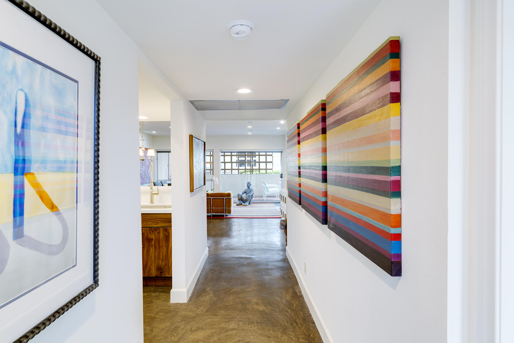 277 East Alejo Road, Unit 101 Palm Springs, CA 92262 - Photo 10 of 30 a hallway with painting on the wall and a large window