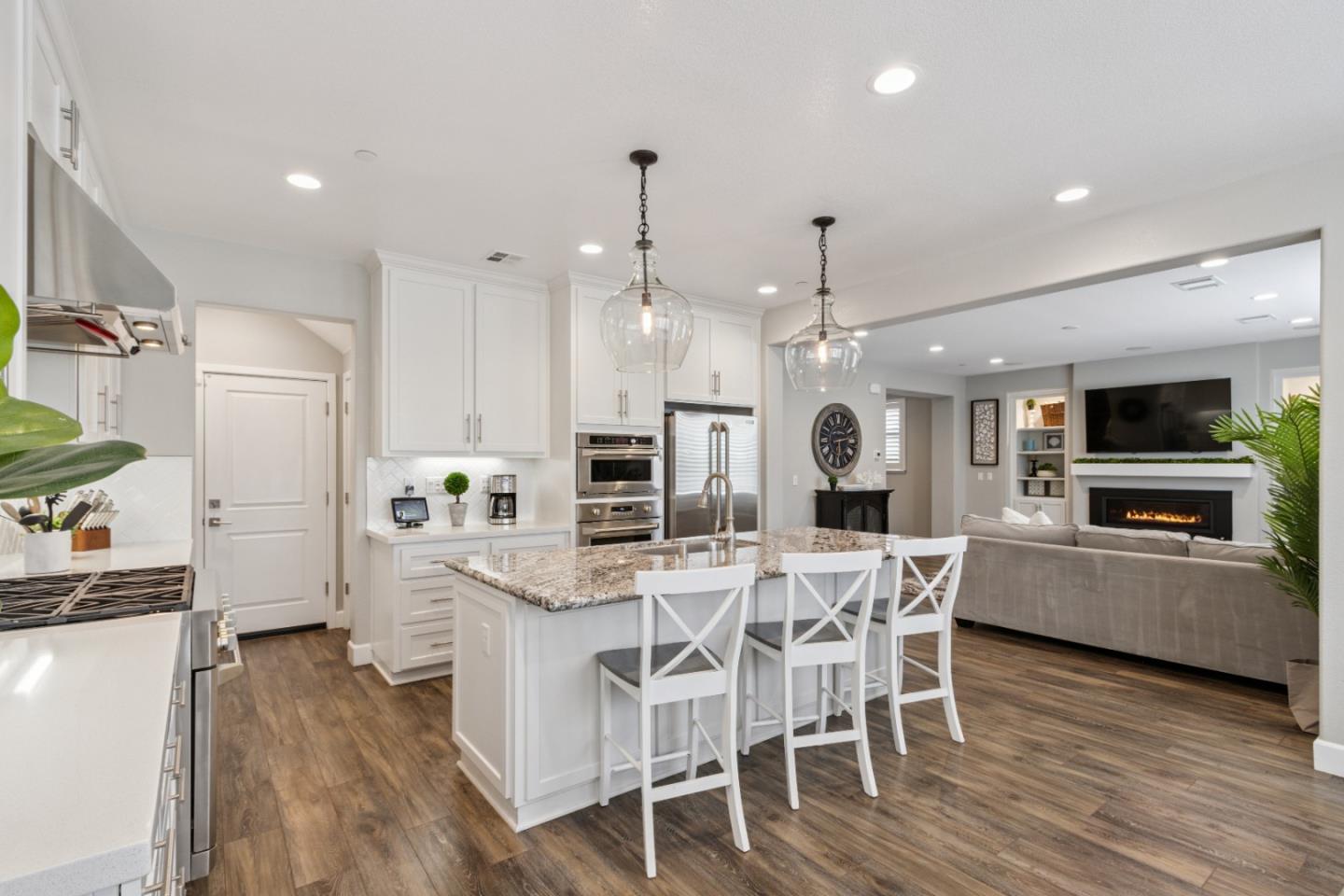 2610 Lighthouse Lane Marina, CA 93933 - Photo 11 of 43 a kitchen with stainless steel appliances kitchen island granite countertop a wooden floor and white cabinets